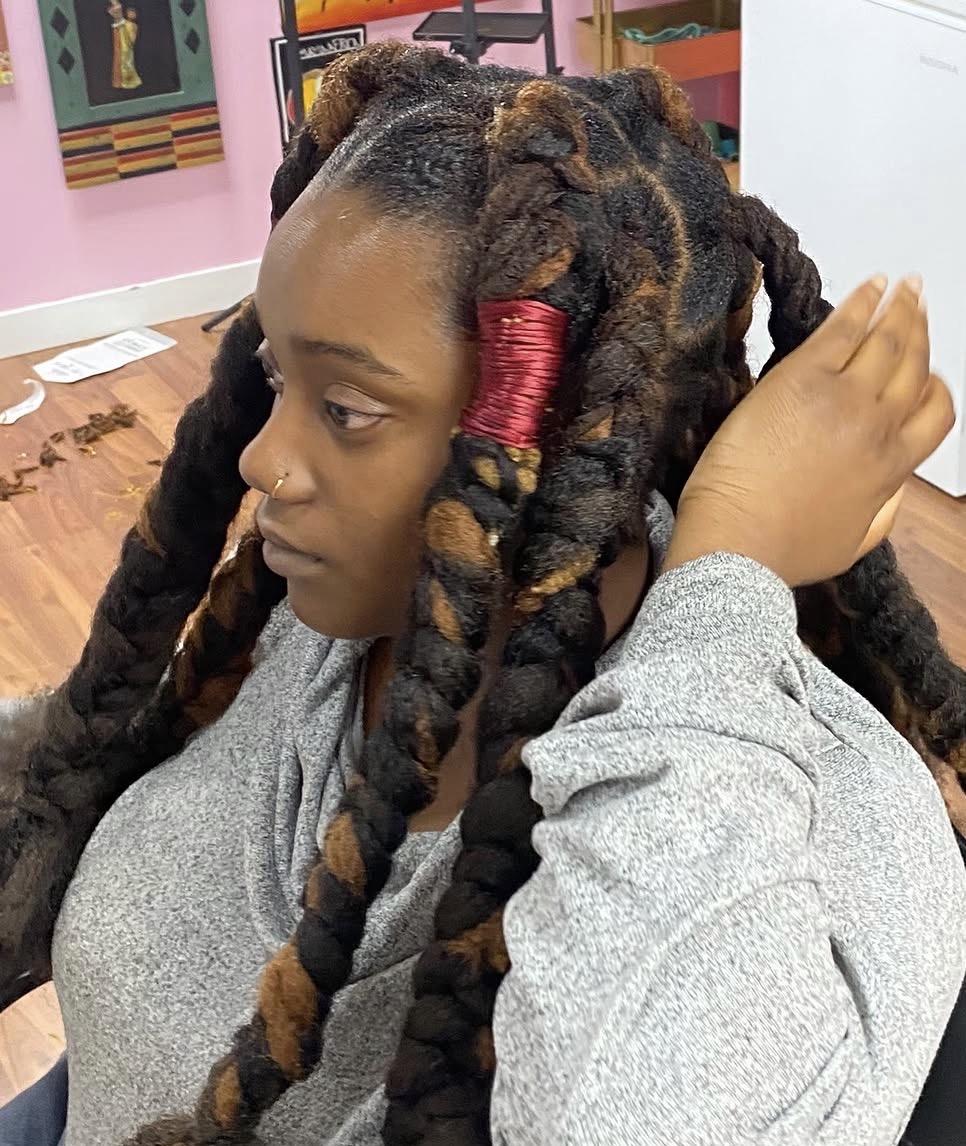 Chunky two-tone braids finished with red thread